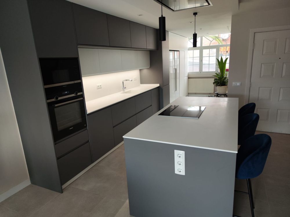 Cocina reformada con isla y estanterías de madera