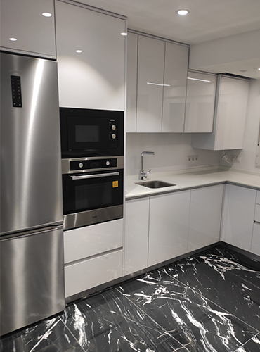 Cocina reformada con muebles blancos y horno integrado